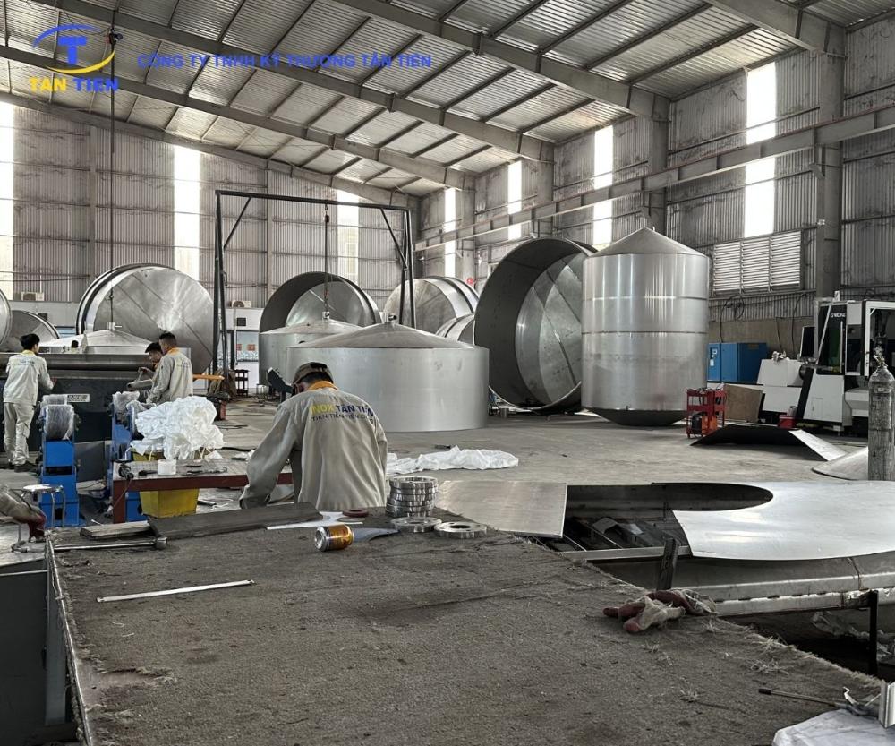 Kỹ sư kiểm tra hoàn thiện bồn phối trộn siro inox vi sinh có thước đo thủy lực tại xưởng sản xuất